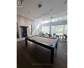 A pool table in a room with a wood floor and a white ceiling.
