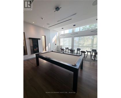 A pool table in a room with a wood floor and a white ceiling.