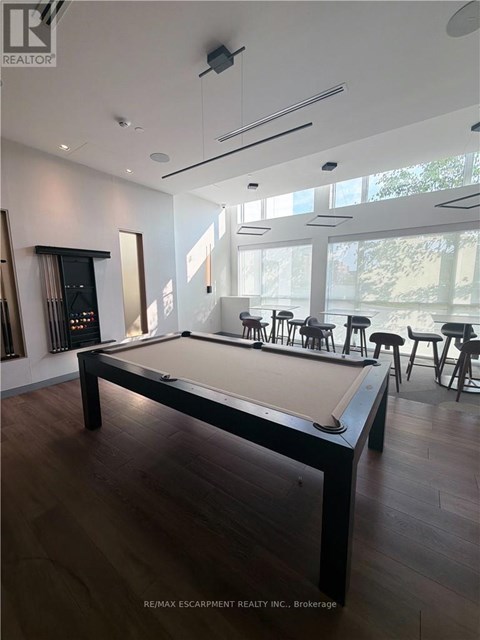 A pool table in a room with a wood floor and a white ceiling.