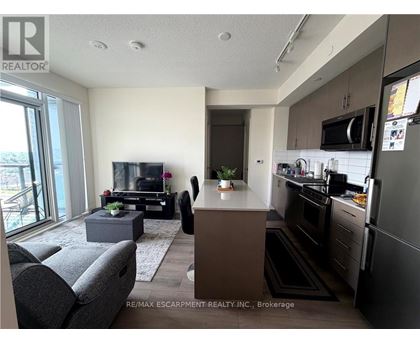 A modern kitchen with dark wood cabinets and stainless steel appliances.