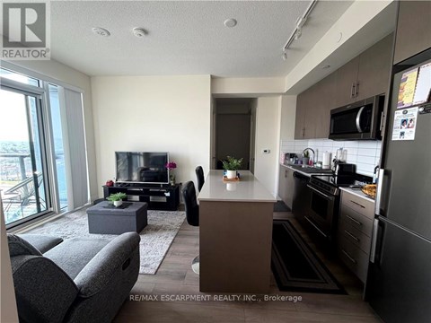 A modern kitchen with dark wood cabinets and stainless steel appliances.