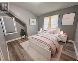 A bedroom with a large bed and a plant on the side table.