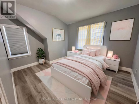 A bedroom with a large bed and a plant on the side table.