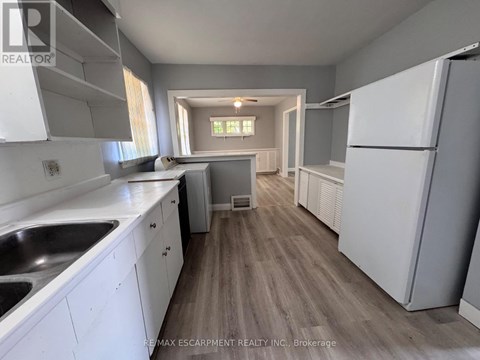 A kitchen with white cabinets and a wooden floor.