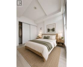 A bedroom with a large bed and a painting on the wall.