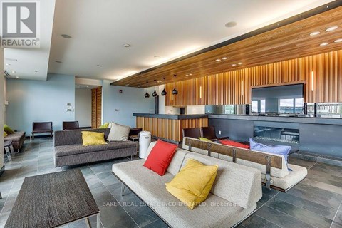 A living room with a grey couch and a wooden wall.