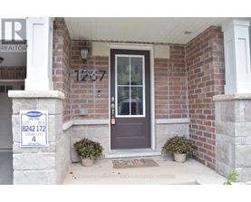 A house with a sign that says "Sale" in front of it.
