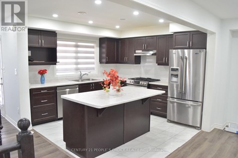 A modern kitchen with dark brown cabinets and stainless steel appliances.