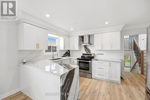 A modern kitchen with white cabinets and a marble island.