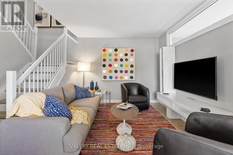 A living room with a grey couch and a white television.