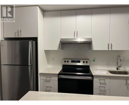 A kitchen with a stainless steel refrigerator, oven, and sink.