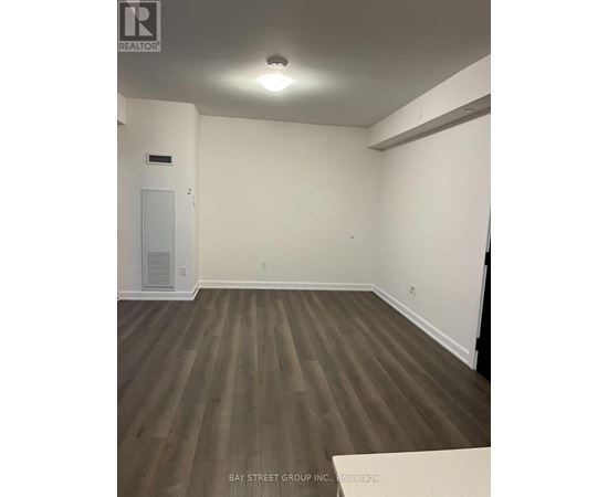 A room with wooden flooring and white walls.