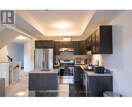 A modern kitchen with dark wood cabinets and stainless steel appliances.