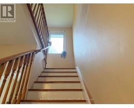 A staircase with a wooden banister and a window at the top.