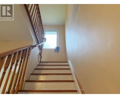 A staircase with a wooden banister and a window at the top.
