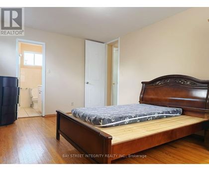 A bedroom with a bed, dresser, and a window.
