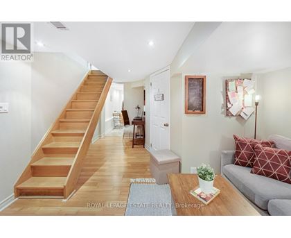 A living room with a couch, coffee table, and stairs.
