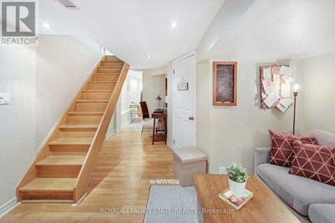 A living room with a couch, coffee table, and stairs.