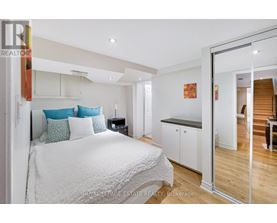 A bedroom with a white bed and a wooden floor.