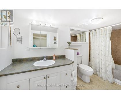 A bathroom with a sink, toilet, and mirror.