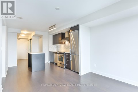 A spacious kitchen with stainless steel appliances and a refrigerator with a water dispenser.