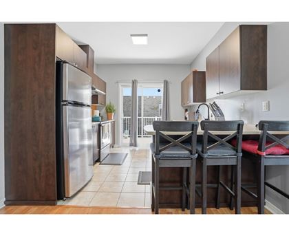 A kitchen with a table and chairs in front of a refrigerator.