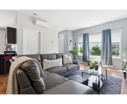 A modern living room with a grey sofa and a glass coffee table.