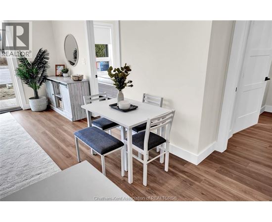A dining room with a white table and chairs.