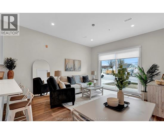 A living room with a white table and a black chair.