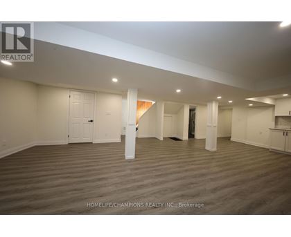 A spacious room with wooden flooring and white walls, ready for a new tenant.