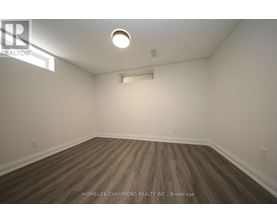 A room with wooden flooring and white walls.