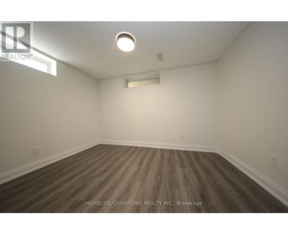 A room with wooden flooring and white walls.