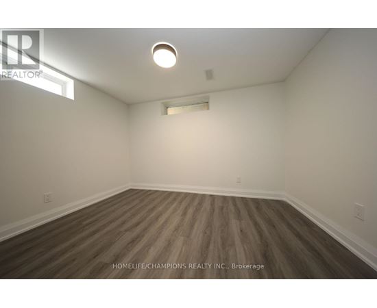 A room with wooden flooring and white walls.