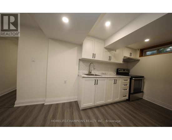 A kitchen with white cabinets and a wooden floor.