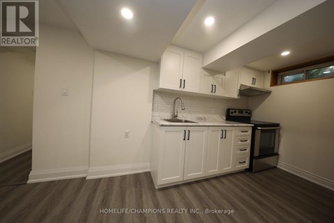 A kitchen with white cabinets and a wooden floor.