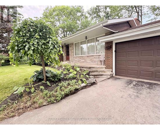 A house with a brown garage door and a tree in front of it.