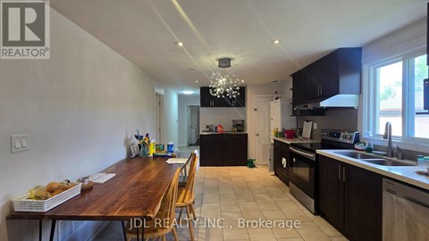 A kitchen with a dining table and chairs in the foreground.