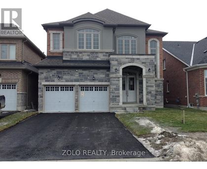 A house with a grey front and a stone wall.