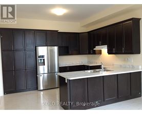 A kitchen with black cabinets and a stainless steel refrigerator.