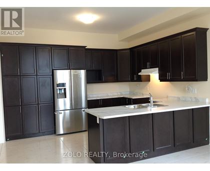 A kitchen with black cabinets and a stainless steel refrigerator.