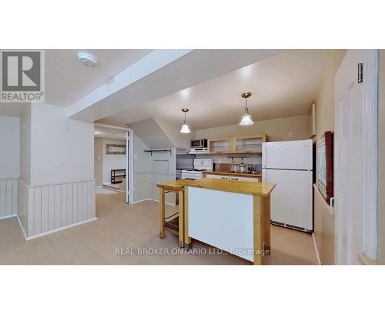 A kitchen with white appliances and wooden cabinets.