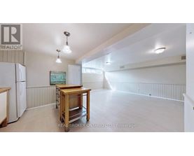A realtor's office with a white fridge and a wooden table.
