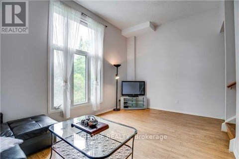 A living room with a glass coffee table and a television.