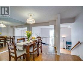 A dining room with a table set for six with a chandelier hanging above it.