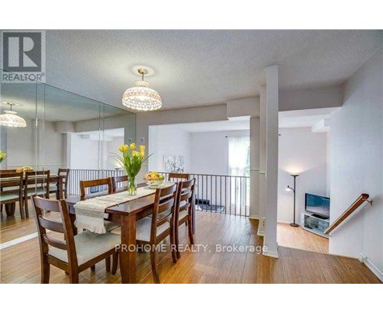 A dining room with a table set for six with a chandelier hanging above it.
