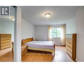 A bedroom with a bed, dresser, and window.