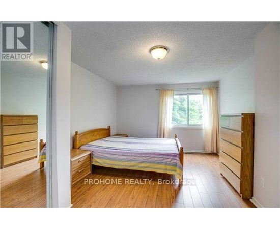 A bedroom with a bed, dresser, and window.