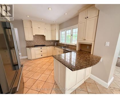 A kitchen with white cabinets and a granite countertop.
