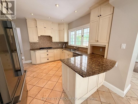 A kitchen with white cabinets and a granite countertop.