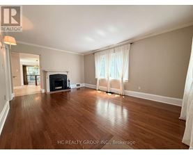 A spacious living room with hardwood floors and a fireplace.
